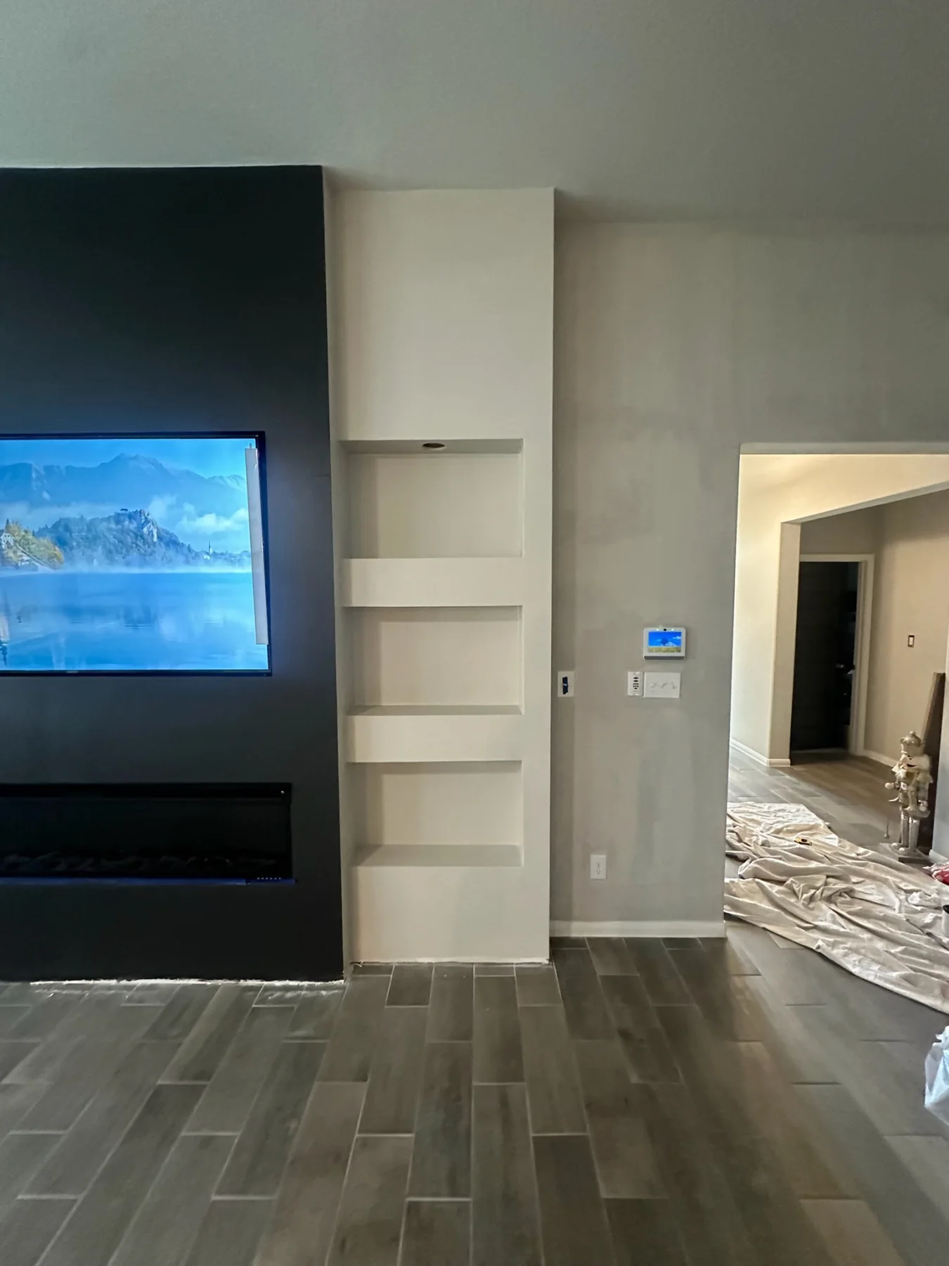 Finished custom media wall with built-in shelves and accent lighting