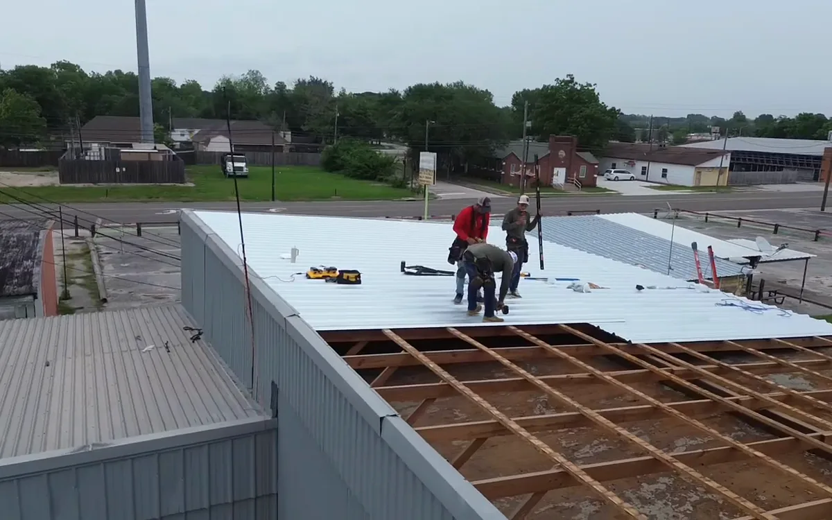TAC crew installing metal roofing on a commercial building