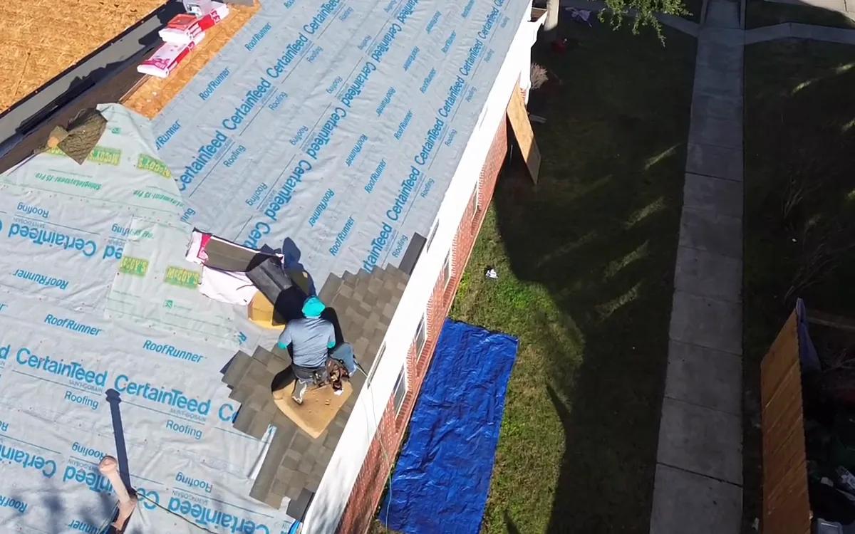 TAC roofer protecting an exposed residential roof during repairs